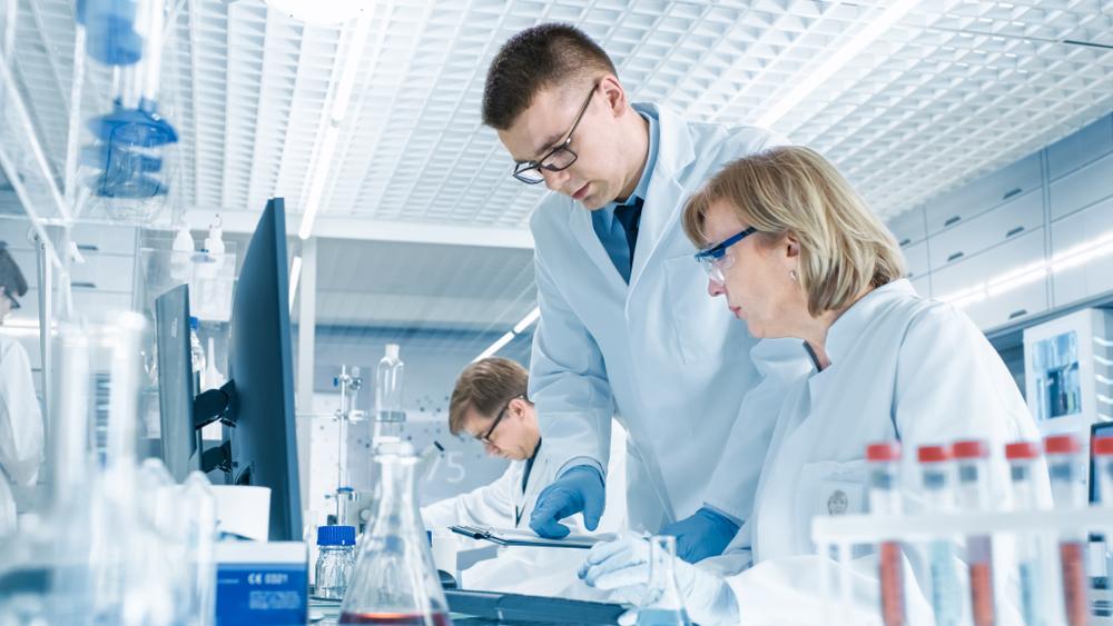 male and female scientist looking at computer data